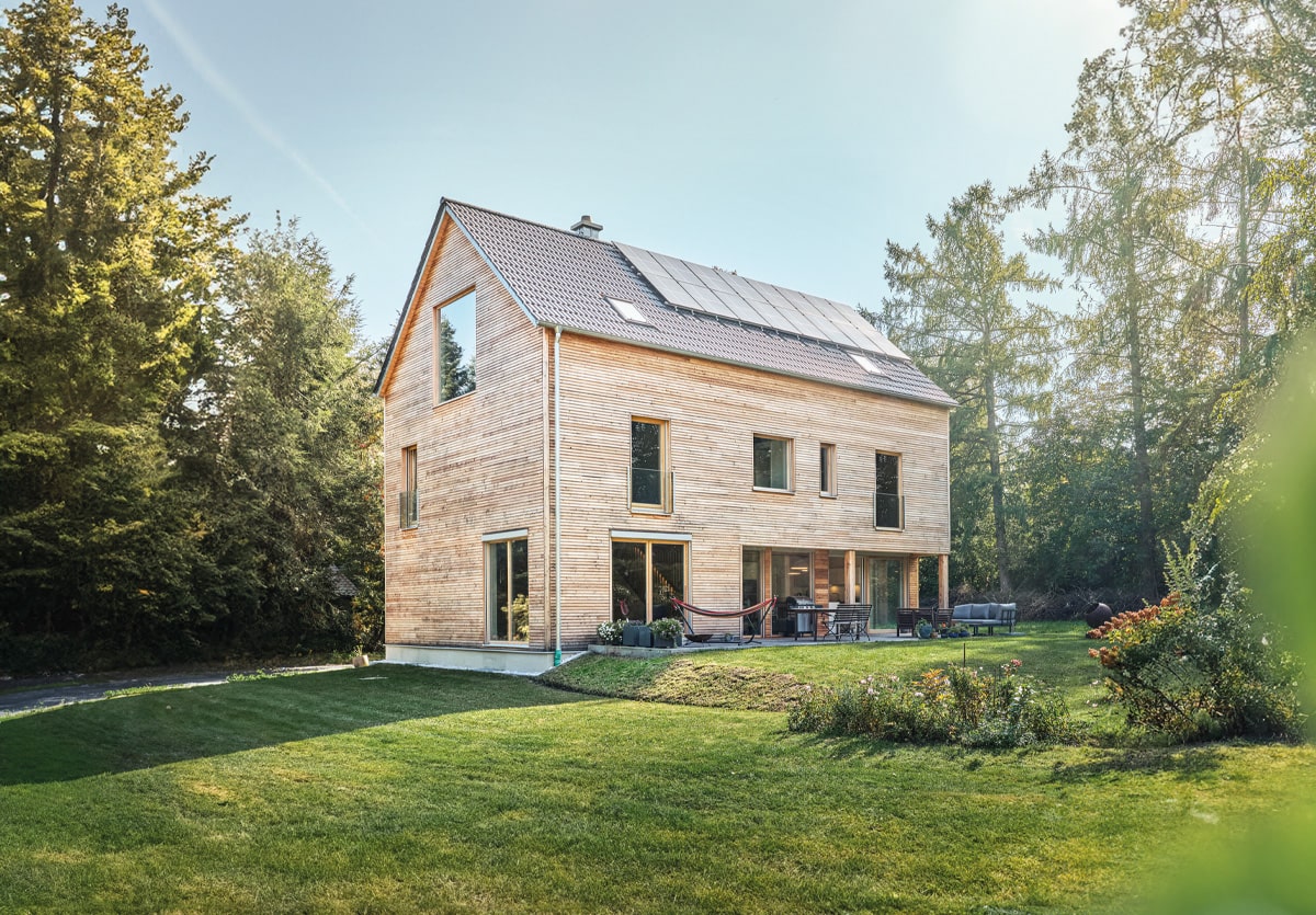 modernes holzhaus münchen mit Lärchenfassade natur, asymmetrischen Fenster, ohne Dachüberstand und großem Garten