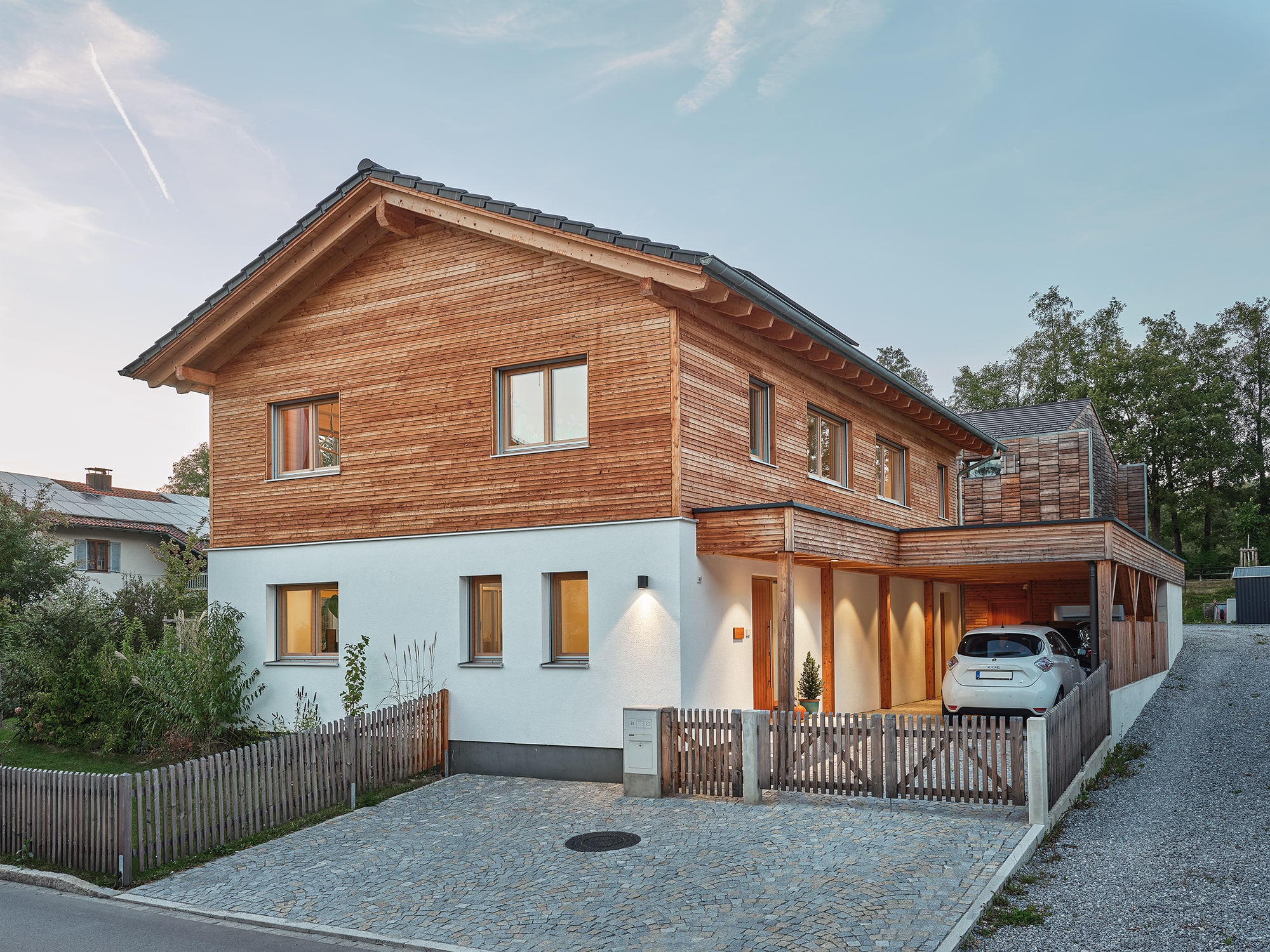 Natürliches, modernes Holzhaus mit Lärchenfassade und Putzfassade